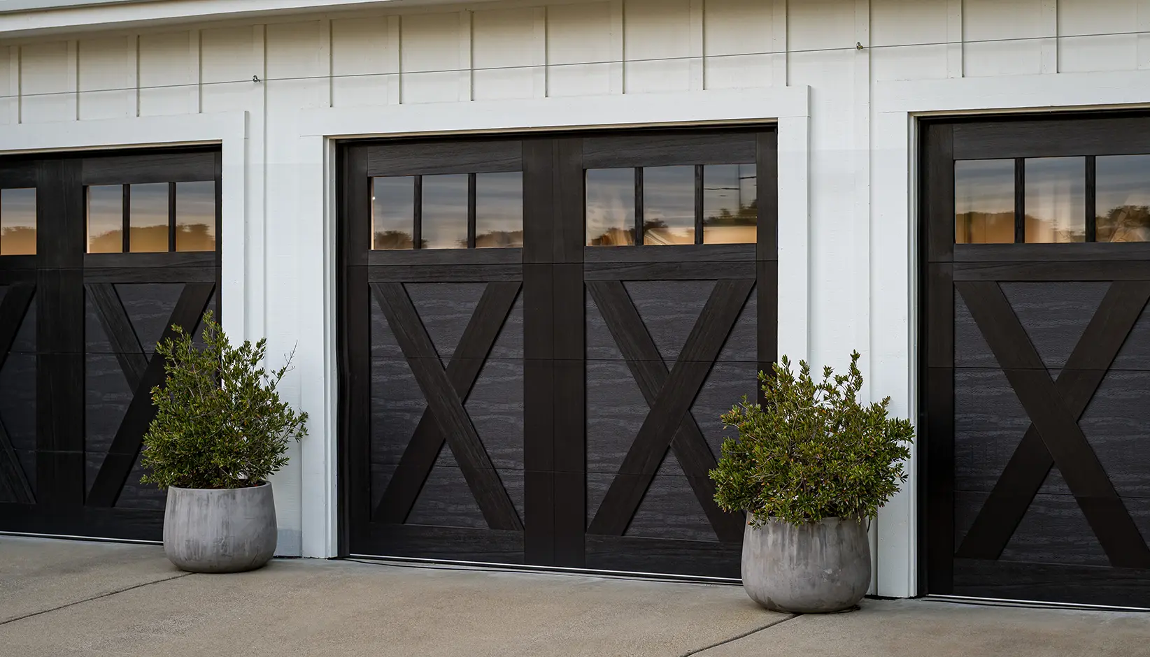 Dark composite overlay carriage house doors with X-brace