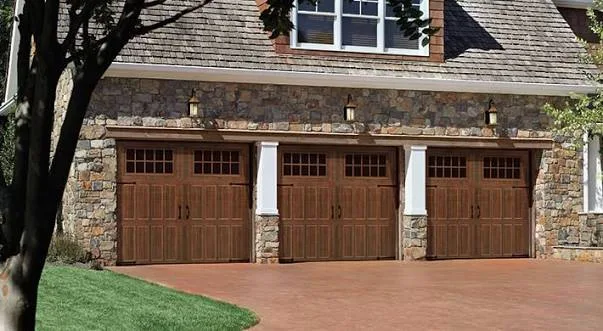 Stamped carriage house garage doors on a stone home